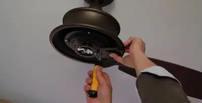 Electrician installing ceiling fan mounting bracket and fixture in Wilmington, NC
