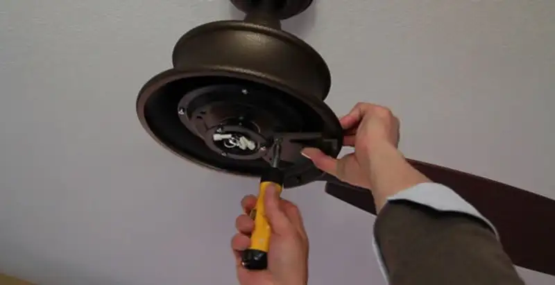 Electrician installing ceiling fan mounting bracket and fixture in Wilmington, NC