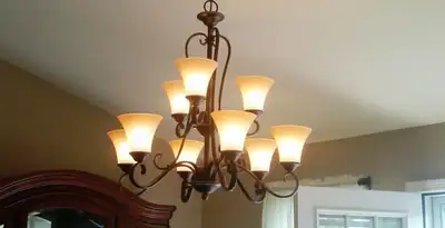 Classic ceiling chandelier installation with warm lighting in Wilmington, NC