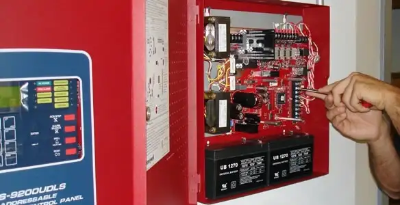 fire alarm installation service showing technician configuring fire alarm control panel in Wilmington, NC