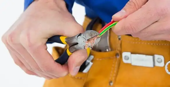 licensed electrician securing electrical wiring with professional tools during service work in Wilmington, NC