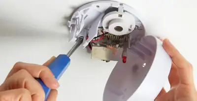 Certified technician wiring smoke detector during installation in Wilmington, NC